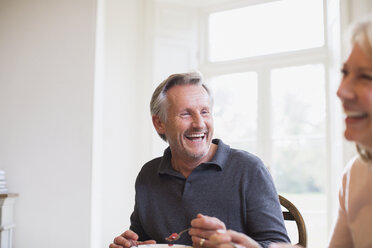 Lachendes reifes Paar beim Essen - HOXF03530