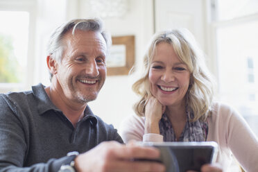 Smiling mature couple using smart phone - HOXF03545