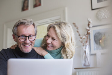 Smiling mature couple using laptop - HOXF03568