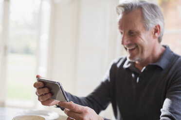 Smiling mature man using smart phone - HOXF03569