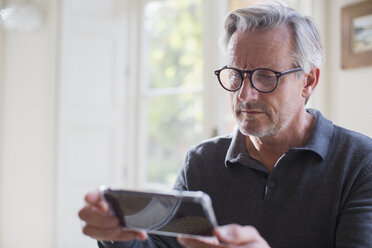 Konzentrierter reifer Mann, der ein Smartphone benutzt - HOXF03582