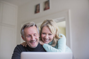 Smiling, happy mature couple using laptop - HOXF03583