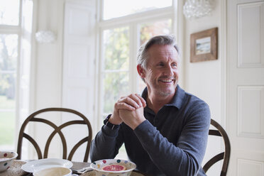 Smiling mature man eating breakfast - HOXF03588