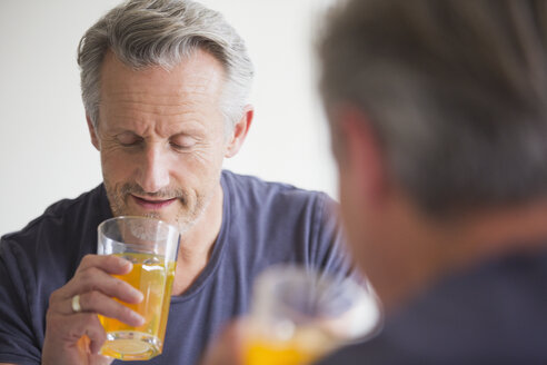 Älterer Mann trinkt Saft am Spiegel - HOXF03606
