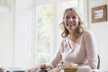 Lächelnde, selbstbewusste reife Frau beim Essen - HOXF03617