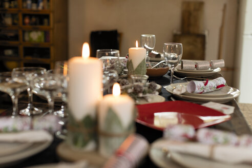 Kerzen, Eindeckungen und Weihnachtskräcker auf dem Tisch - CAIF20516