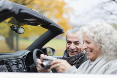 Älteres Paar mit Digitalkamera im Cabrio, lizenzfreies Stockfoto