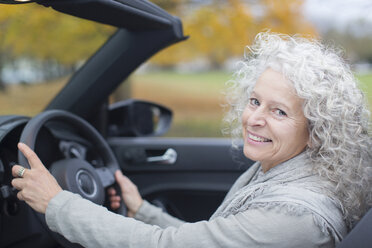 Porträt lächelnde ältere Frau am Steuer eines Cabriolets - CAIF20528