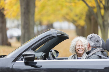 Smiling senior couple talking in convertible - CAIF20529