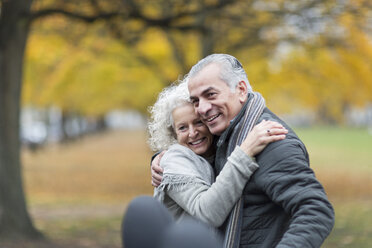 Happy senior couple hugging in autumn park - CAIF20530