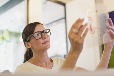 Designer examining transparency diagram in office - CAIF20571