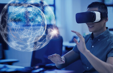 Computerprogrammierer, der eine Virtual-Reality-Simulatorbrille testet und ein Projektionshologramm betrachtet - CAIF20576