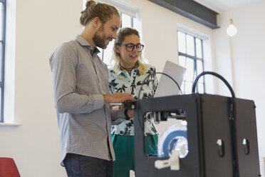 Designer mit Laptop neben dem 3D-Drucker im Büro - CAIF20586