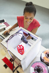 Lächelnde Designerin beobachtet 3D-Drucker im Büro - CAIF20587
