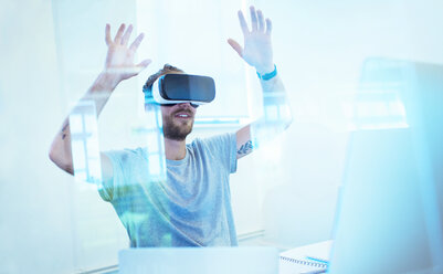 Männlicher Computerprogrammierer testet Virtual-Reality-Simulator-Brille im Büro - CAIF20588