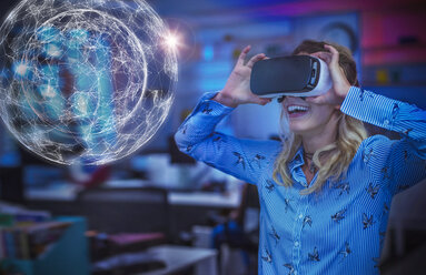 Enthusiastic female computer programmer testing virtual reality simulator glasses, viewing futuristic hologram - CAIF20589