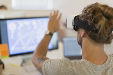 Computerprogrammierer testet Virtual-Reality-Simulator-Brille am Computer im Büro - CAIF20600