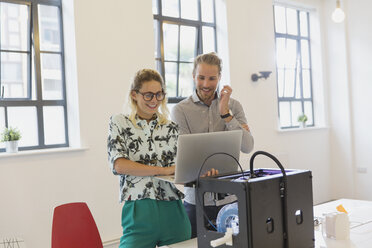 Designer mit Laptop am 3D-Drucker im Büro - CAIF20616