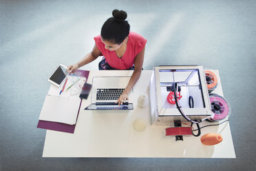 Female designer at laptop next to 3D printer - CAIF20631