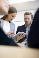 Junge Geschäftsfrau und Mann verwenden digitalen Tablet-Touchscreen am Konferenztisch - CUF09863