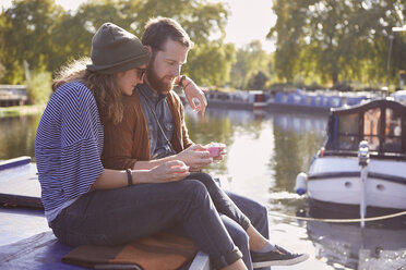 Couple eating cupcakes on canal boat - CUF09918