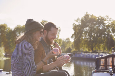 Couple eating cupcakes on canal boat - CUF09925