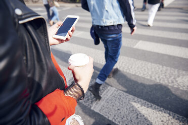 Person auf dem Fußgängerüberweg mit Kaffee und Smartphone - CUF10020