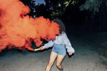 Woman holding flare in park at night - CUF10060