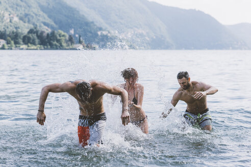 Drei junge erwachsene Freunde spielen Kampf im Comer See, Como, Lombardei, Italien - CUF10080