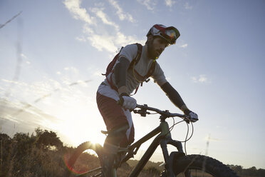 Male mountain biker biking on moorland - CUF10116