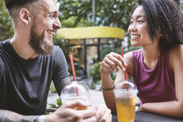 Multi ethnic hipster couple talking at sidewalk cafe, Shanghai French Concession, Shanghai, China - CUF10131