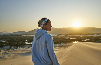 Frau schaut bei Sonnenuntergang über Dünen weg, Florianopolis, Santa Catarina, Brasilien, Südamerika - CUF10186