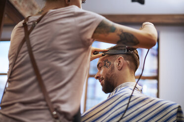 Friseur rasiert das Haar eines Kunden - CUF10197
