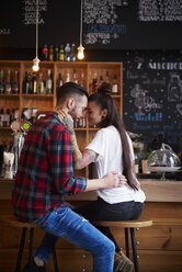 Paar auf Hockern im Café von Angesicht zu Angesicht lächelnd - CUF10201