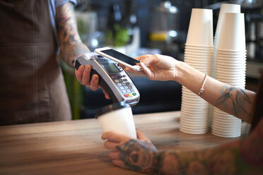 Customer paying for her coffee by mobile payment - CUF10223
