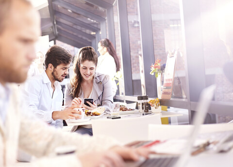 Geschäftsleute und Frau beim Arbeitsessen im Restaurant, lizenzfreies Stockfoto