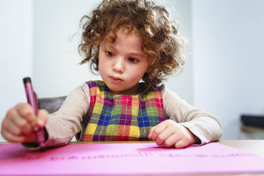 Girl drawing on pink paper at table - CUF10272