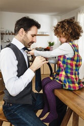 Mädchen bindet die Krawatte des Vaters in der Küche - CUF10275