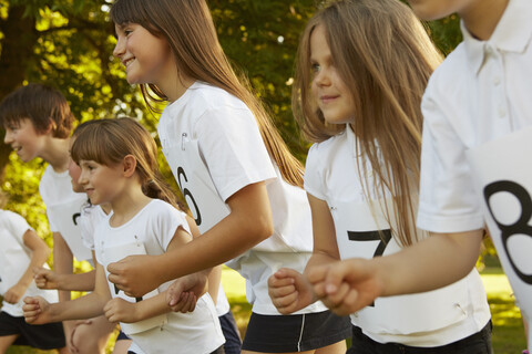 Row of boys and girls on race starting line on playing field stock photo