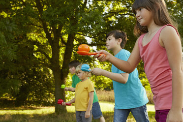 Girls and boys doing egg and spoon race in park - CUF10345