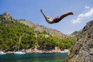 Junger Mann taucht ins Meer, Cala Tuent, Mallorca, Spanien - CUF10377