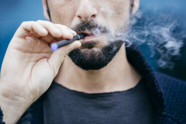 Porträt eines Mannes, der eine elektronische Zigarette raucht - CUF10395