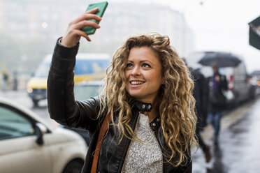 Frau auf der Straße nimmt Selfie - CUF10396