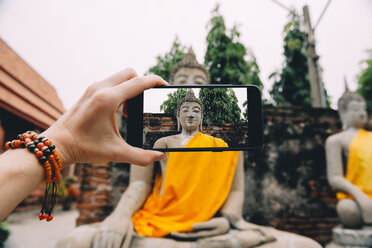 Thailand, Ayutthaya, Wat Yai Chai Mongkhon, Fotografieren von Buddha mit Smartphone - GEMF01990
