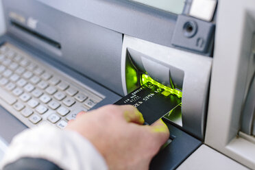 Close up of woman's hand inserting credit card into cash machine - CUF10420