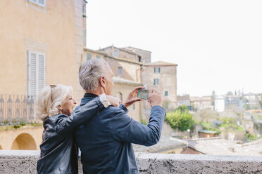 Tourist couple photographing cityscape, Siena, Tuscany, Italy - CUF10421