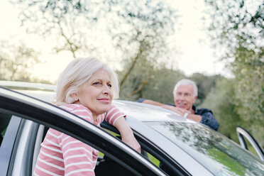 Tourist couple looking out from car doors in rural spot, Siena, Tuscany, Italy - CUF10434