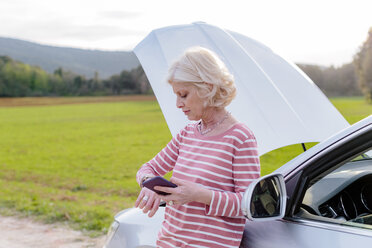 Female tourist with car breakdown waiting on rural roadside, Siena, Tuscany, Italy - CUF10435