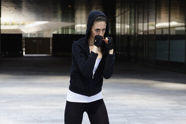 Young woman outdoors, exercising, in fighting stance - CUF10475