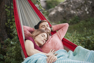 Couple relaxing in hammock, eyes closed sleeping, Krakow, Malopolskie, Poland, Europe - CUF10485